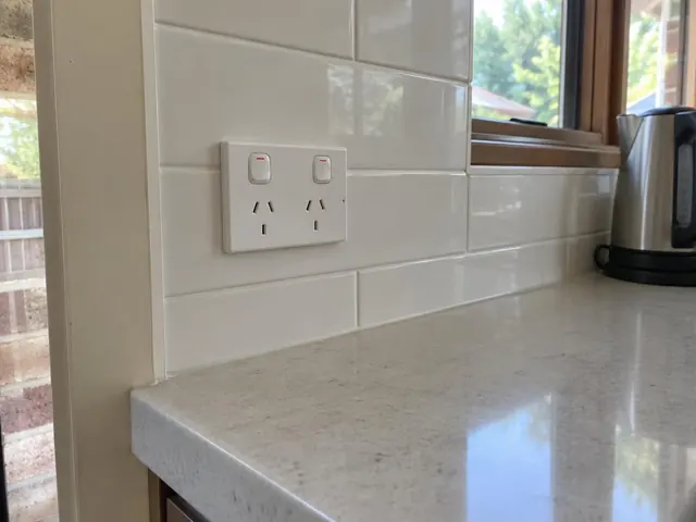 Tiled kitchen splashback with a double power point above a benchtop in Point Frederick