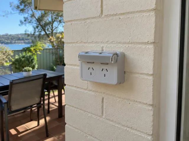 Outdoor double power point on a painted brick wall beside a patio in Point Clare